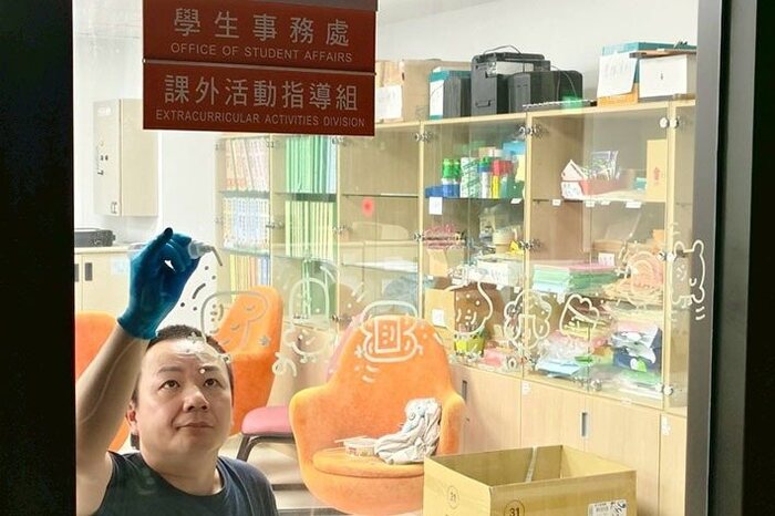 藝術家大石曉規在全人教育大樓窗面繪製微笑角色